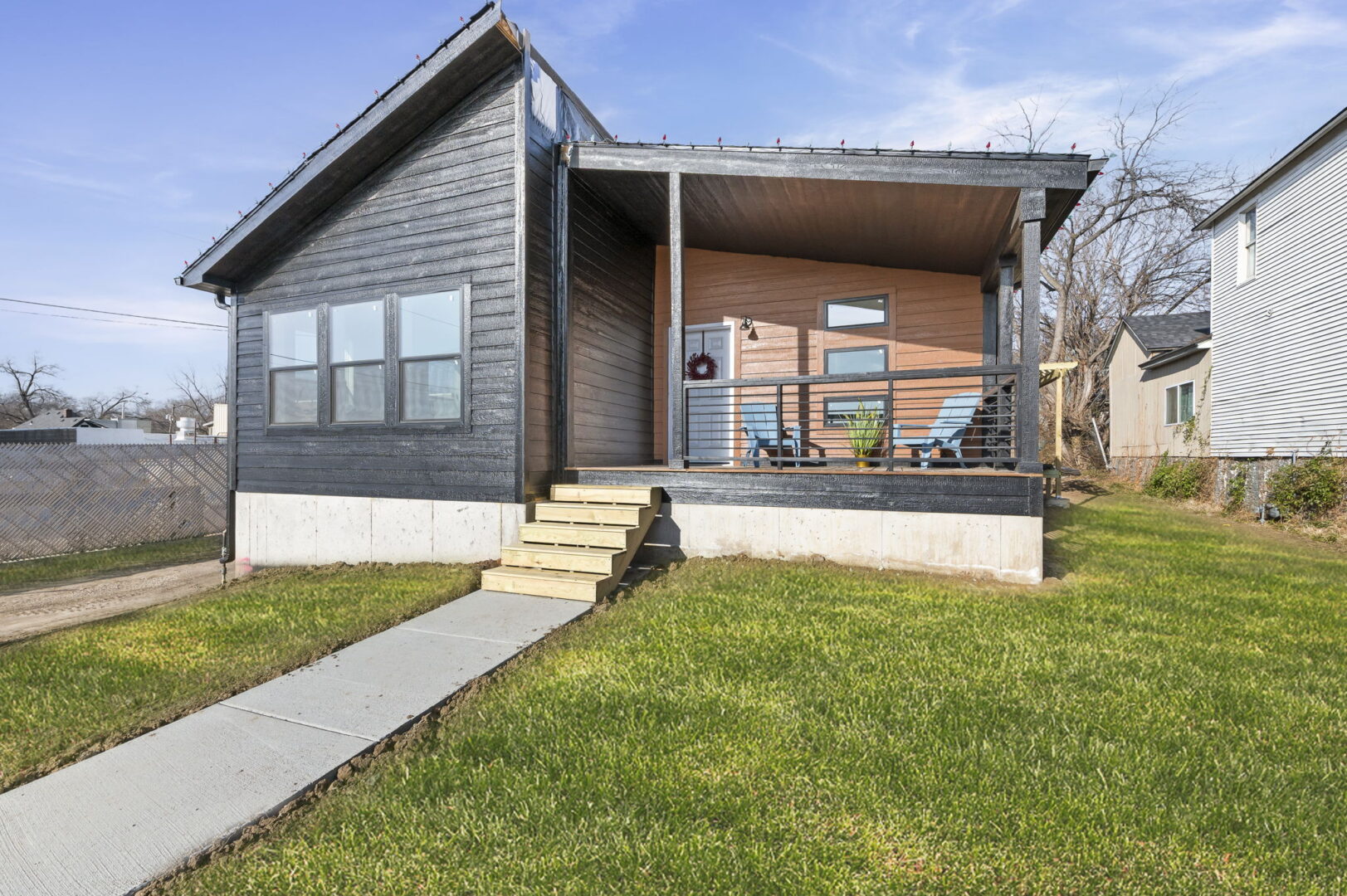 A single story home with a cute and cozy front porch.