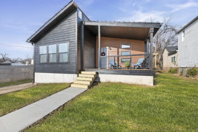 A single story home with a cute and cozy front porch.