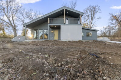 A two-story home with a green and light brown exterior.