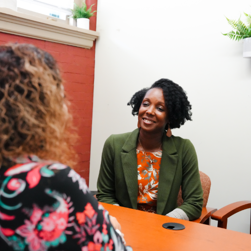 A customer sits with a counselor in an office.